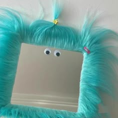 a mirror that has some kind of blue furry thing on it's face and eyes