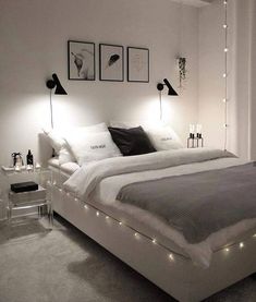 a white bed with lights on the headboard and foot board is in a bedroom