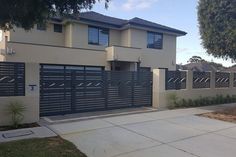 a two story house with an attached driveway and fenced in area next to it