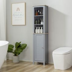 a white toilet sitting next to a gray cabinet in a bathroom near a bathtub