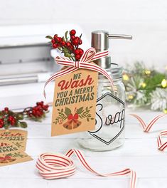 a glass bottle with a christmas message on it sitting next to some candy canes