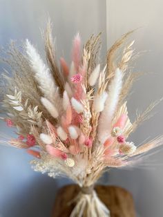 a vase filled with lots of dried flowers