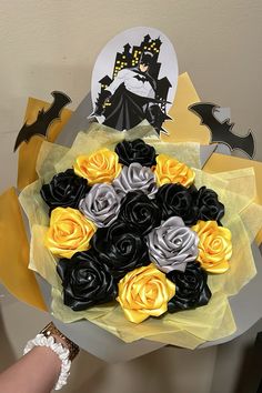 a person holding a bouquet of flowers in front of a wall with batman stickers on it