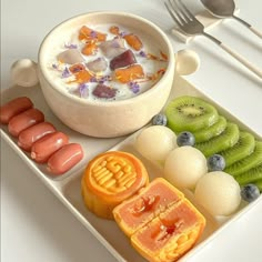 a white plate topped with fruit and veggies next to a bowl of yogurt