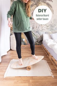 a woman standing on top of a surfboard in the middle of a wooden floor