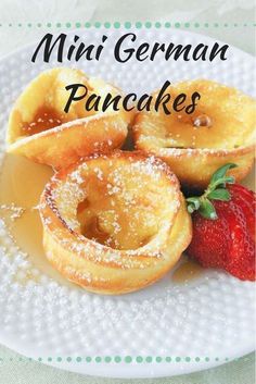 mini german pancakes with powdered sugar and strawberries on a white plate, ready to be eaten