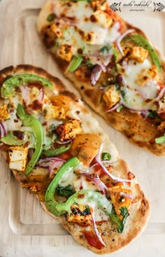 two flat bread pizzas with different toppings on a cutting board