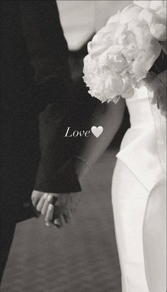 a bride and groom holding hands with the word love written on it in black and white