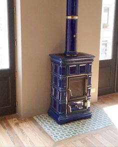 a blue stove sitting in the corner of a room next to a door and window