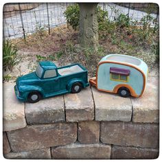 a toy truck and trailer sitting on top of a stone wall