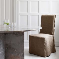 a marble table with a chair and vase on it