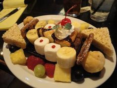 a white plate topped with lots of different types of food on top of a table