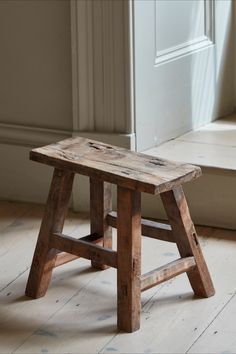 an old wooden step stool sitting in front of a door