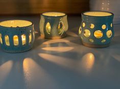 three tea light holders sitting on top of a table