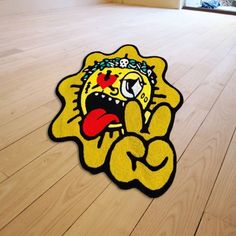 a yellow rug with a cartoon character on the floor in front of a wooden floor