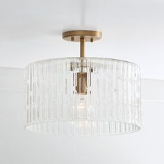 a chandelier hanging from the ceiling in a room with white walls and flooring