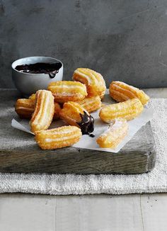 donuts on a wooden board with dipping sauce