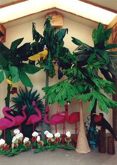 there are many fake plants and birds in the room