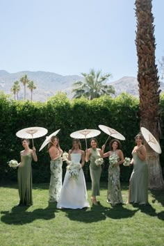 a group of women standing next to each other holding umbrellas