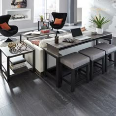 a living room filled with lots of furniture and decor on top of a hard wood floor