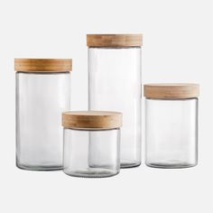 three glass jars with wooden lids on white background