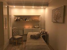 a spa room with candles and towels on the bed, lights in the corner above