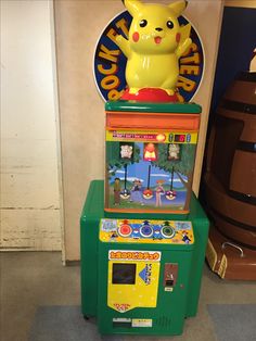 an arcade machine with a pikachu figure on top and other machines in the background