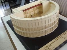 a model of a building on top of a table next to a plaque with writing