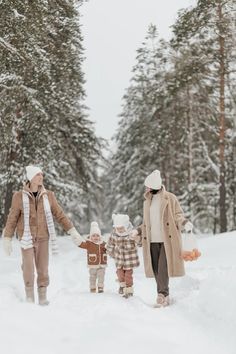 an older woman and two young children are walking in the snow with their hands together