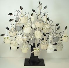 a crocheted owl tree is shown on a black stand with white and gray owls