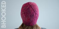 the back of a woman's head wearing a pink knitted hat