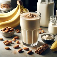 there is a drink with almonds and milk in the glass on the table next to some bananas