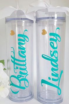 two personalized tumblers are sitting next to white flowers