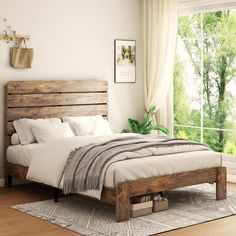 a bed with white linens and wooden headboard in a bedroom next to a window