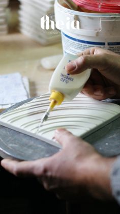 a person is pouring something into a container