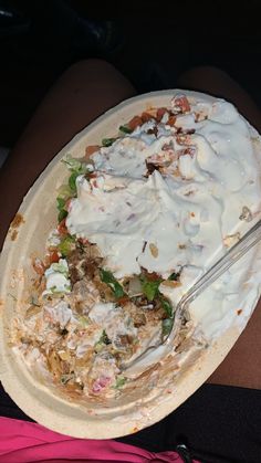 a person is holding a plate with food on it and a fork in the bowl