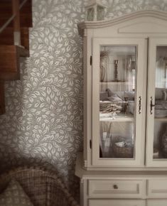 a white china cabinet sitting next to a stair case