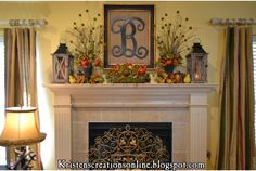 a fireplace mantel decorated with flowers, candles and an ornate monogram above it