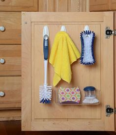 the kitchen cabinet door is open to reveal cleaning supplies