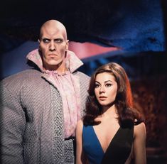 a woman standing next to a man in a blue dress