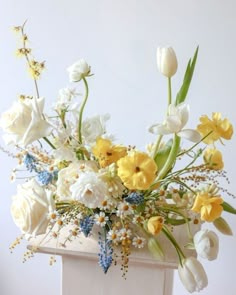 a vase filled with lots of white and yellow flowers