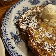 french toast topped with ice cream on a blue and white plate