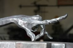 a metal sculpture is shown in the shape of a hand