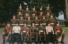 a group of men in uniform sitting next to each other on top of a bench