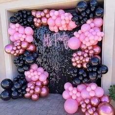 a pink and black door decorated with balloons