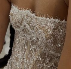 the back of a woman's dress with white flowers on it and lace detailing