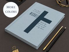 there is a book with the letter f on it and some pens next to it