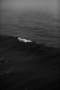 a black and white photo of a wave in the ocean