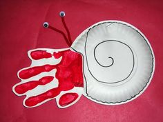 a paper plate with an image of a hand and a snail painted on the side