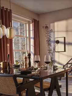 a dining room table and chairs with candles on it in front of the large window